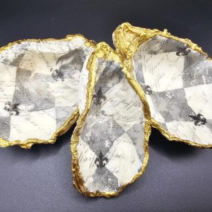 Three white ceramic bowls with jagged gold rims arranged on a dark surface.